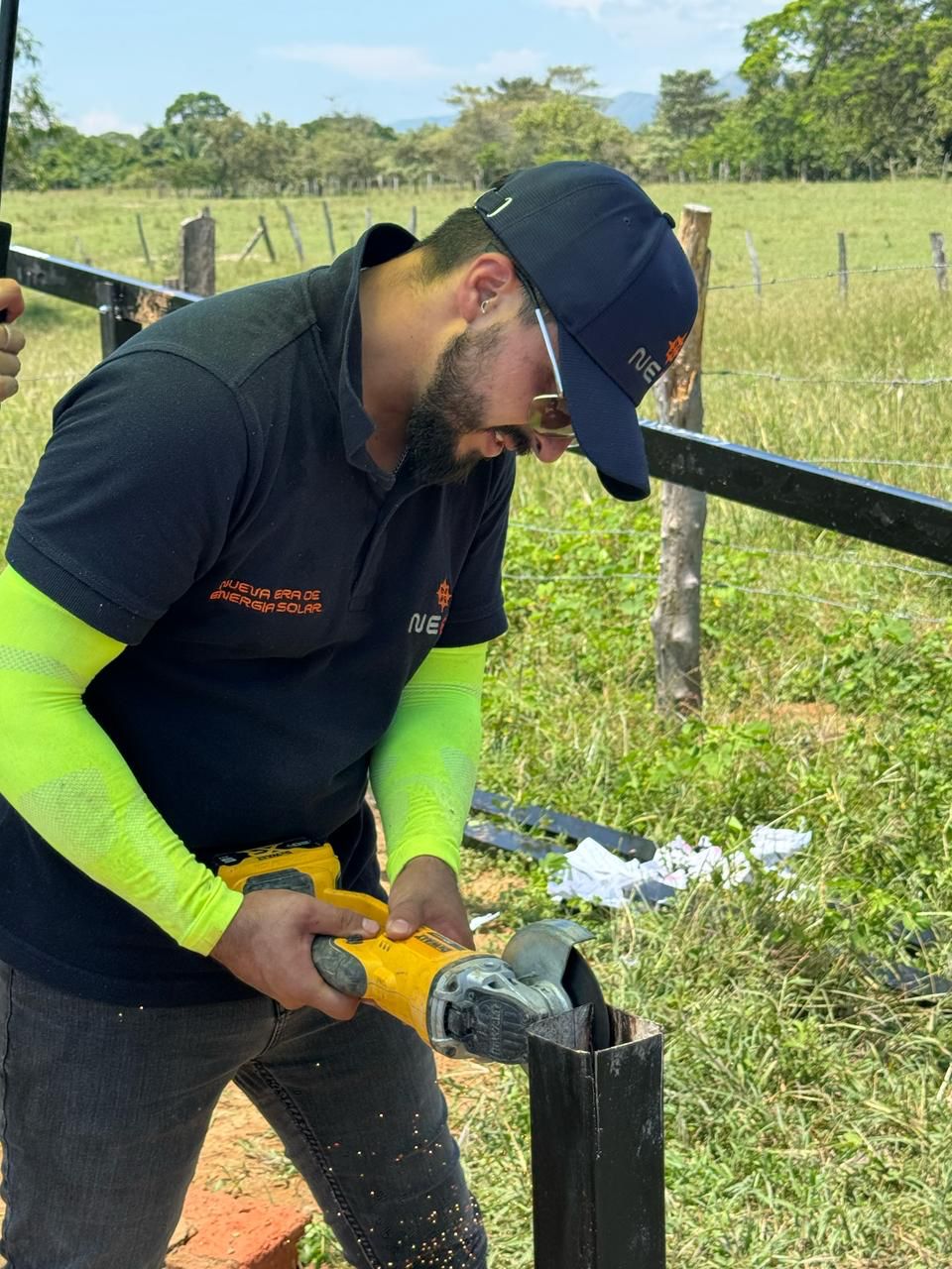 Técnico de NEES armando la estructura metálica para paneles solares en campo abierto
